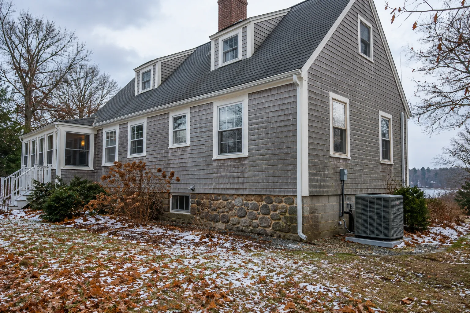 A cozy older home in the Brewster area with an outdoor AC unit beside the foundation
